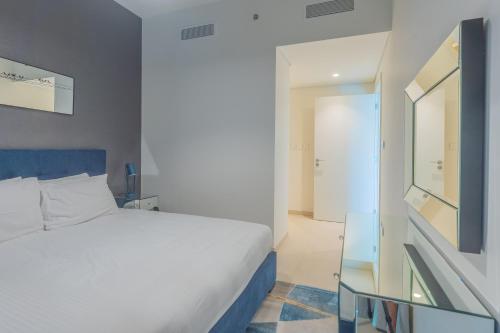 a bedroom with a white bed and a glass table at Bellavista Apartments Holiday Homes LLC - Downtown Views II T1 - 2 Bedroom Apartment with Burj Khalifa View in Dubai