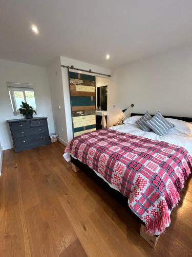 a bedroom with a bed and a dresser in it at 1 Woodlands in Llandysul