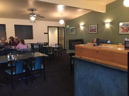 un comedor con gente sentada en las mesas en Breeze Inn Motel, en Seward