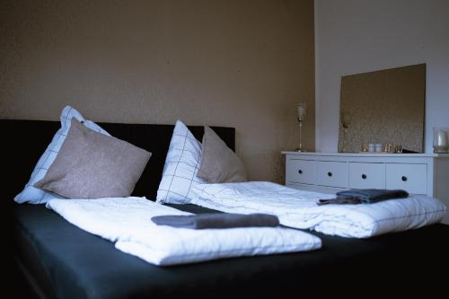 two beds with white sheets and pillows on them at Stadtwohnung mit Stadtpark Blick in Emden