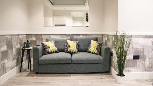 a couch in a living room with a mirror at The Pillar Hotel in London
