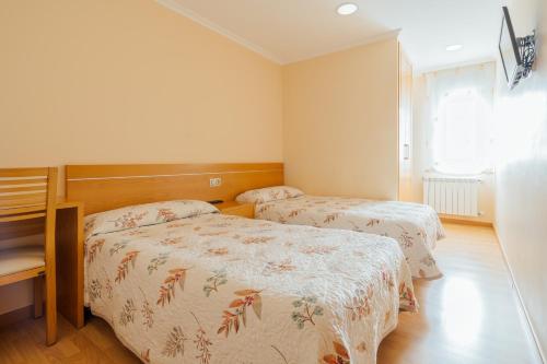 a bedroom with two beds and a window at Hotel Restaurante Cazador in Pereiro