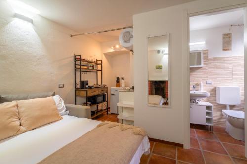 ein Schlafzimmer mit einem Bett und ein Badezimmer mit einem Waschbecken in der Unterkunft Lilliput Apartment by Wonderful Italy in Bellagio