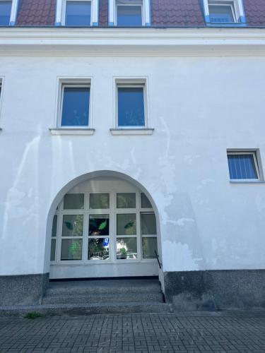 a white building with a large window on it at Joli Bord Apartment in Warsaw