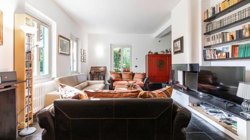 sala de estar con sofá y TV en Italianway - Villa Visconta, en Briosco