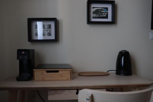a desk with a computer and a speaker and pictures on the wall at B&B La Casetta in Cambiago
