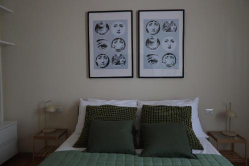 een slaapkamer met drie foto's boven een bed bij B&B La Casetta in Cambiago