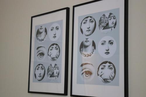 two framed pictures of faces on a wall at B&B La Casetta in Cambiago