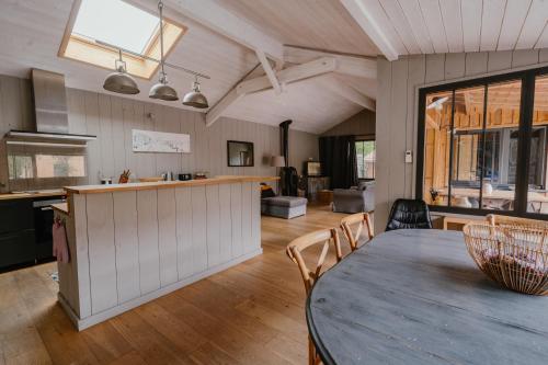 - une cuisine et un salon avec une table et un comptoir dans l'établissement Superbe villa Obordelo à 50 m de la plage., à Andernos-les-Bains