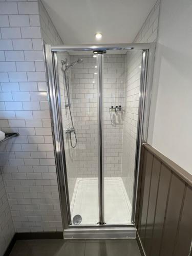 a shower with a glass door in a bathroom at White Horse in Maldon