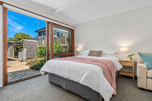 a bedroom with a bed and a large window at Hampton Vintage Soul with Pool in Melbourne