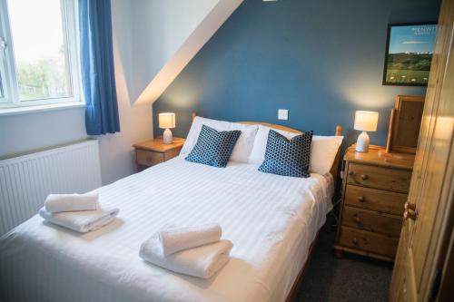 a bedroom with a bed with two towels on it at White Rose Cottages, Near Thirsk in Thirsk