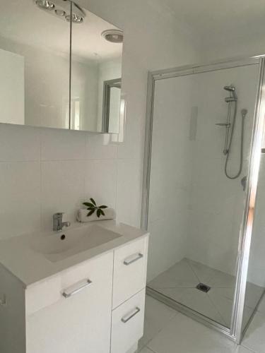 een witte badkamer met een douche en een wastafel bij 25 Wentworth Street shepparton in Shepparton