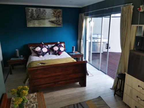 a bedroom with a bed and a sliding glass door at Walmer Heights Guest House in Port Elizabeth