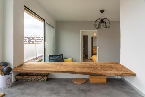 - un grand banc en bois dans une chambre avec fenêtre dans l'établissement F2 HyperCentre Clermont Ferrand, à Clermont-Ferrand