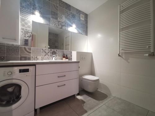 a bathroom with a washing machine and a toilet at Apartamenty Tychy Kopernika in Tychy