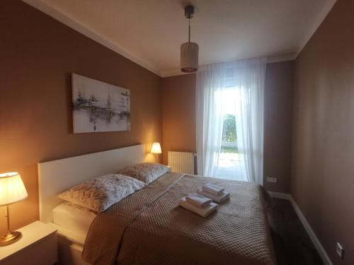 a bedroom with a bed with two towels on it at Apartamenty Tychy Kopernika in Tychy