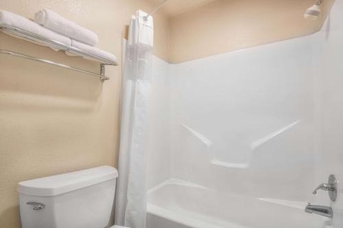 uma casa de banho com um WC branco e um chuveiro em Days Inn by Wyndham San Antonio Interstate Hwy 35 North em San Antonio