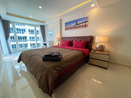a bedroom with a large bed with red pillows at Large Deluxe Condo 5 Grand Avenue Central Pattaya in Pattaya Central