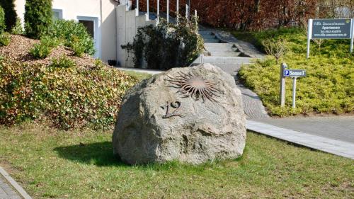 Ein Stein mit einem Gesicht im Gras in der Unterkunft Villa Sonnenterrasse in Pelzerhaken