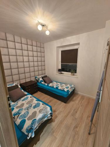 a room with two beds and a window at Apartament Panorama Miasta in Gdynia