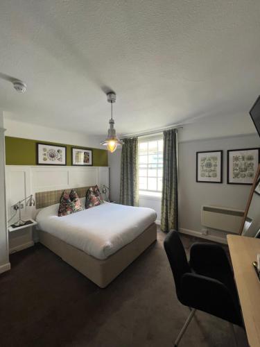 a bedroom with a large white bed and a window at White Horse in Maldon