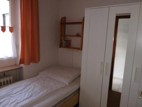 シャルボイツにあるFerienwohnung-115-im-Berliner-Hofの小さなベッドと窓が備わる小さな客室です。