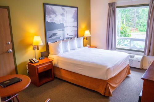 a hotel room with a large bed and a window at Super 8 by Wyndham Amherst NS in Amherst