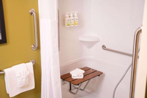 a bathroom with a shower and a table with towels at Super 8 by Wyndham Amherst NS in Amherst