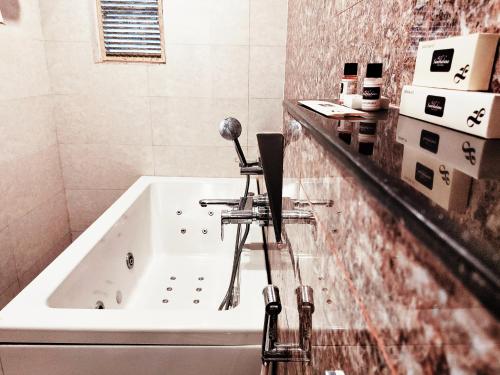 a bathroom with a bath tub and a sink at Sambhabana Hotel & Suites in Tarapith