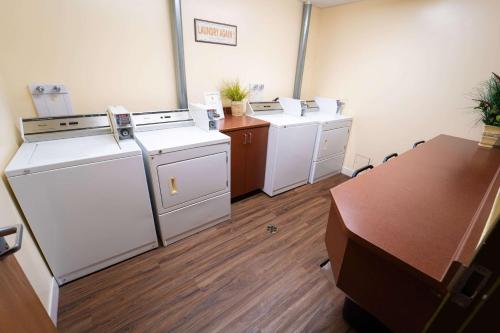 ein Büro mit zwei Waschmaschinen, einem Schreibtisch und einem Tisch in der Unterkunft Super 8 by Wyndham Amherst NS in Amherst