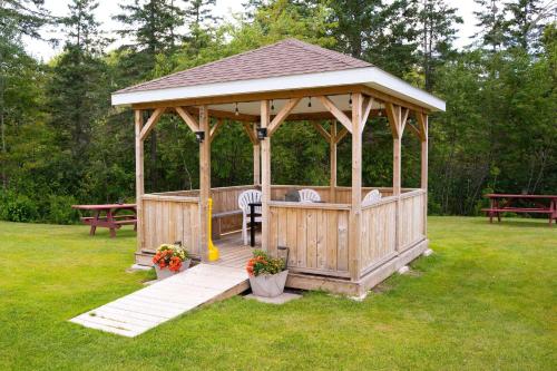 a wooden gazebo with a table and benches at Super 8 by Wyndham Amherst NS in Amherst