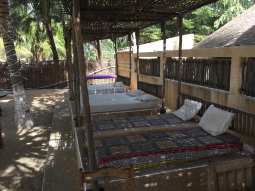 un porche con 2 camas en una habitación en Keur des pecheurs chez ivan, en Ouoran
