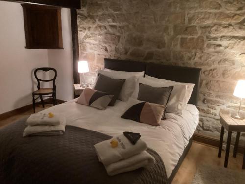 a bedroom with a large bed with towels on it at Heather Cottage Bakewell in Bakewell