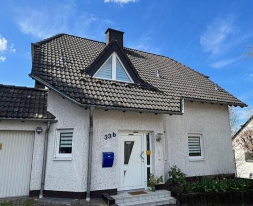 a white house with a gambrel roof at Gartenparadies Apartment in Urbar in Urbar