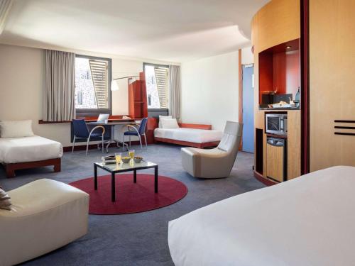 une chambre d'hôtel avec un lit et un salon dans l'établissement Novotel Suites Marseille Centre Euromed, à Marseille
