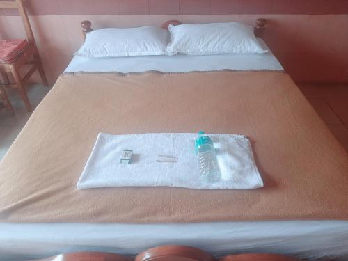 uma garrafa de água sentada em cima de uma cama em Vega Residency And Bike Rentals em Madikeri