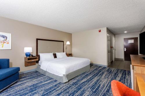 a hotel room with a bed and a blue couch at Hampton Inn Titusville/I-95 Kennedy Space Center in Titusville