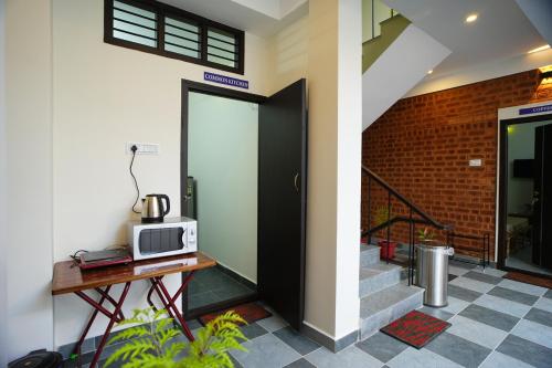 eine Tür zu einem Gebäude mit einer Mikrowelle auf dem Tisch in der Unterkunft UNGA VEEDU PAY AND STAY in Tiruvannāmalai