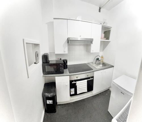 una cucina bianca con lavandino e forno a microonde di Aroluchi Ville - Cosy Studio 