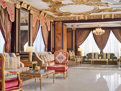 فندق موڤنبيك سيتي ستار جدة في جدة: غرفة معيشة مليئة بالاثاث والثريا