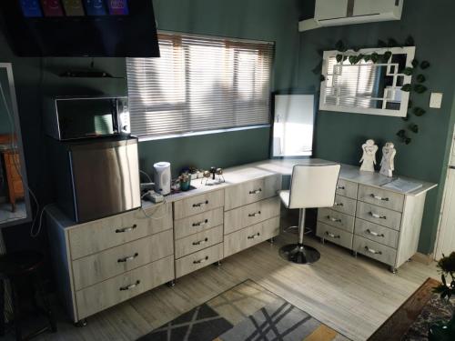 a kitchen with a sink and a microwave at Walmer Heights Guest House in Port Elizabeth
