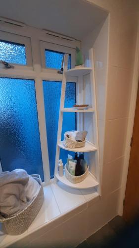 a room with a window with two shelves in a bathroom at Joiners cottage in Penrith