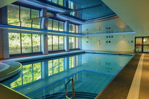 ein großer Pool mit einem großen Fenster in einem Gebäude in der Unterkunft Hampshire Court Hotel & Spa in Basingstoke