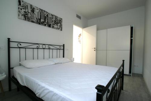 1 dormitorio con 1 cama grande con sábanas blancas en VILLAGGIO LIDO - Cavallino en Cavallino-Treporti