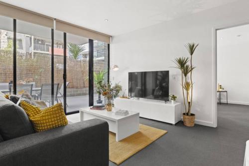 a living room with a couch and a tv at Ink Echelon Escape in Melbourne