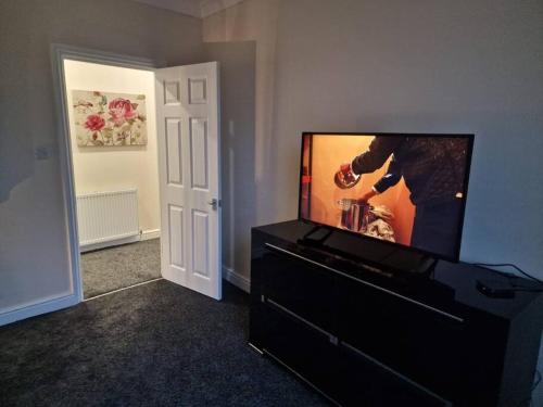 una sala de estar con TV de pantalla plana en una cómoda en Levy Nook 4 en Darlington