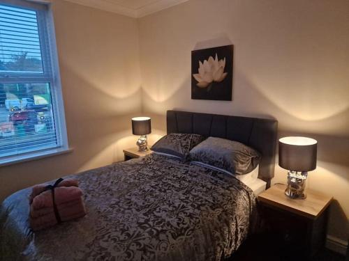 a bedroom with a bed with two lamps and a window at Levy Nook 4 in Darlington