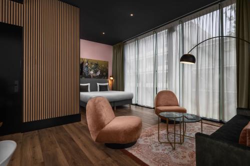 a bedroom with a bed and a couch and chairs at Hotel2Stay in Amsterdam