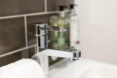 a bathroom sink with a chrome bathroom faucet at Edinburgh Castle Apartments in Edinburgh